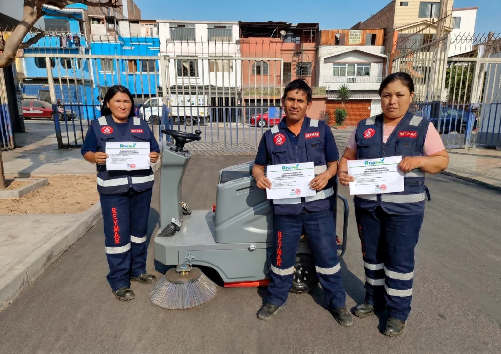 Operario de Limpieza de Corporación Reymar con sus certificado de capacitación sobre maquina barredora industrial hombre abordo